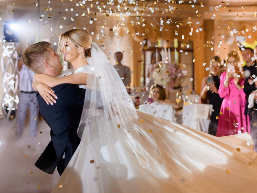 bride-couple-waving-while-dacning-with-confetti_8353-12337